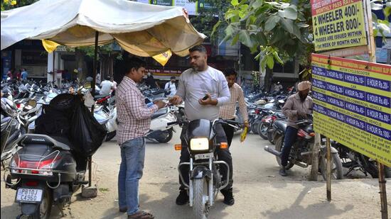 Parking attendants issuing tickets to visitors at an MC parking lot in Ludhiana. (Manish/HT)