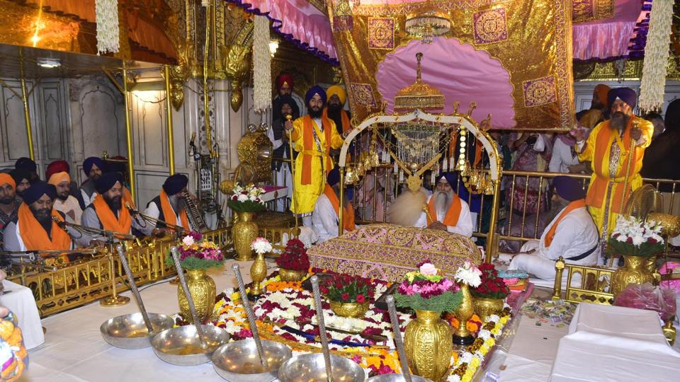Akal Takht Jathedar Giani Raghbir Singh sits beside the Guru Granth Sahib (Sikh holy book) and the Jalau (show of splendour) in the sanctum sanctorum inside the Golden Temple on the occasion of the 554th birth anniversary of Guru Nanak Dev on Monday. (Sameer Sehgal/HT)