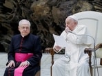 Pope Francis coughs as Monsignor Leonardo Sapienza looks on during the weekly general audience, in the Paul VI hall at the Vatican.