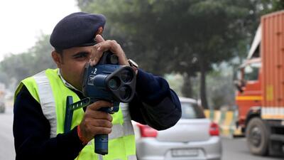 Noida traffic police personnel uses a speed gun on Wednesday to fine vehicles going over the speed limit. (Sunil Ghosh/HT Photo) Noida traffic police personnel uses a speed gun on Wednesday to fine vehicles going over the speed limit. (Sunil Ghosh/HT Photo)