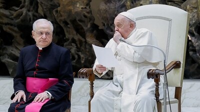 Pope Francis coughs as Monsignor Leonardo Sapienza looks on during the weekly general audience, in the Paul VI hall at the Vatican. (REUTERS)