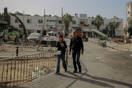 Palestinians walk past the Al-Shifa hospital in Gaza City on November 26, 2023, on the third day of a truce between Israel and Hamas. (AFP) Palestinians walk past the Al-Shifa hospital in Gaza City on November 26, 2023, on the third day of a truce between Israel and Hamas. (AFP)