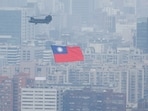 China-Taiwan Conflict: A Chinook helicopter carrying a Taiwan flag flies over the city during the country's National Day celebration in Taipei, Taiwan.