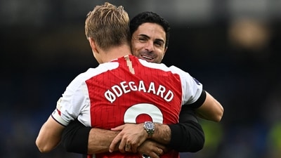 Norwegian midfielder Martin Odegaard is embraced by Spanish manager Mikel Arteta on the pitch after the English Premier League football match between Everton and Arsenal at Goodison Park. (AFP)
