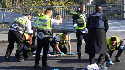 Iraeli rescuers inspect the scene of a shooting attack in Jerusalem (AFP)