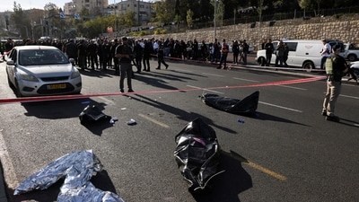 Israeli rescuers cover the body of a victim at the scene of a shooting in Jerusalem near the Jewish settlement of Ramot with nine casualties reported. (REUTERS)
