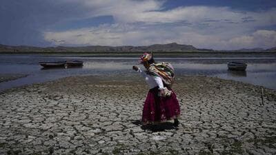 Maruja Inquilla walks on a dried out portion of Lake Titicaca in Coata, Peru, Wednesday, Nov. 29, 2023, due to falling water levels amid a winter heat wave. (AP)