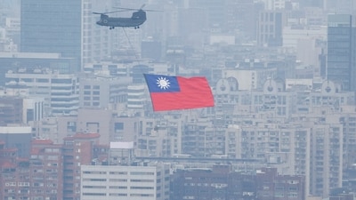 China-Taiwan Conflict: A Chinook helicopter carrying a Taiwan flag flies over the city during the country's National Day celebration in Taipei, Taiwan. (Reuters)