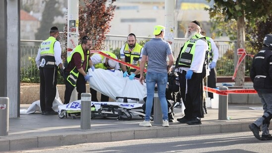 Israeli rescuers place the body of a victim on a gurney at the site of a shooting in Jerusalem.(AFP)