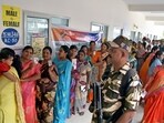 Women voters show their ID cards as they stand in a queue to cast their votes for the Telangana Assembly elections, in Hyderabad on Thursday. 