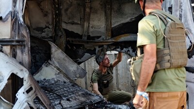 Israel-Hamas War: Members of the Israeli security forces check a destroyed vehicle after it was hit by a rocket fired from the Gaza Strip. (AFP) Israel-Hamas War: Members of the Israeli security forces check a destroyed vehicle after it was hit by a rocket fired from the Gaza Strip. (AFP)