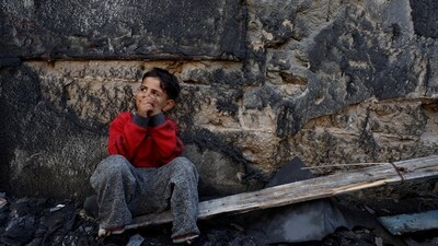 Israel-Hamas War: A Palestinian child sits near the site of Israeli strikes on houses after a temporary truce between Hamas and Israel expired. (Reuters)