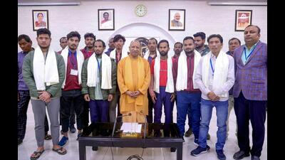 Uttar Pradesh chief minister Yogi Adityanath poses for a group picture with the workers rescued from Silkyara tunnel, after their felicitation ceremony, in Lucknow on Friday. (ANI Photo)