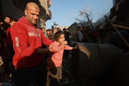 A wounded man helps a girl out of a bombarded area in the Rafah refugee camp in the southern Gaza Strip on December 1, 2023, (Photo by MOHAMMED ABED / AFP) (AFP) A wounded man helps a girl out of a bombarded area in the Rafah refugee camp in the southern Gaza Strip on December 1, 2023, (Photo by MOHAMMED ABED / AFP) (AFP)