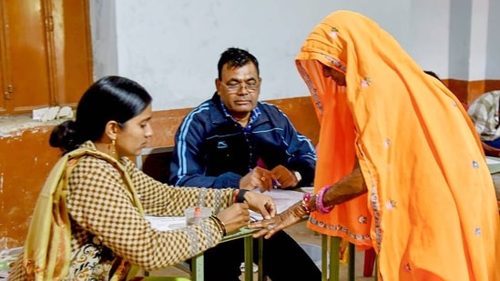 Polling official administering indelible ink to a voter, at a polling booth in Rajasthan. Polling official administering indelible ink to a voter, at a polling booth in Rajasthan.