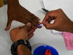 Exit poll 2023 live updates: A polling officer marks the finger of a voter at a polling station during Telangana state assembly elections.(AFP)