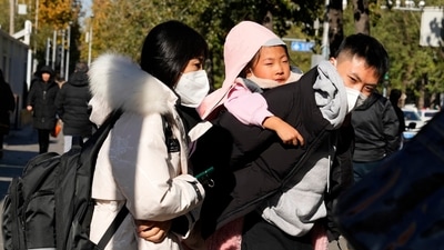 A man carries a child as they leave a children's hospital in Beijing. (AP) A man carries a child as they leave a children's hospital in Beijing. (AP)