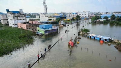Commuters wade across a flooded street after heavy rains in Chennai on December 1, 2023. (Photo by R. Satish BABU / AFP) (AFP) Commuters wade across a flooded street after heavy rains in Chennai on December 1, 2023. (Photo by R. Satish BABU / AFP) (AFP)