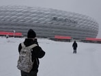 People take pictures of Bayern Munich's Allianz Arena which is covered in snow after heavy snowfall hit Bavaria and its capital Munich, Germany, December 2, 2023. German Bundesliga soccer match FC Bayern Munich v 1. FC Union Berlin had to be cancelled, trains halted and the airport closed because of the weather condition 