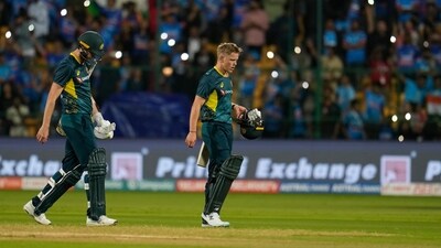 Nathan Ellis, right, and Jason Behrendorff walks off the field after losing the fifth T20I against India in Bengaluru (AP)