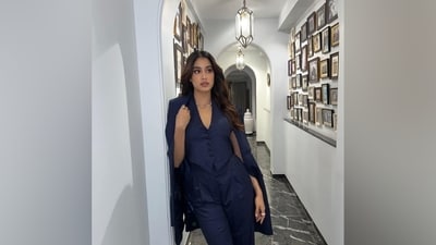 Janhvi completed her outfit with a matching long blazer featuring a double-breasted front, padded shoulders, notch lapel collars, full-length sleeves, a relaxed fit, and ornated embellished buttons. She draped the jacket over her shoulders to bring the look together. (Instagram) Janhvi completed her outfit with a matching long blazer featuring a double-breasted front, padded shoulders, notch lapel collars, full-length sleeves, a relaxed fit, and ornated embellished buttons. She draped the jacket over her shoulders to bring the look together. (Instagram)