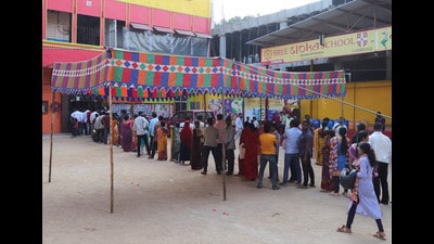 People stand in a queue to cast their vote outside a polling station during the Telangana elections. (REUTERS)