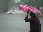 A pedestrian wades through a flooded street after heavy rains in Chennai.