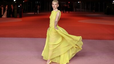 Julia Garner served a Belle Of The Ball moment on the red carpet in a dreamy sleeveless yellow gown featuring a semi-sheer silhouette. She wore the 3.1 Phillip Lim dress with matching pumps, gem-adorned brooches, statement earrings, a sleek updo, and minimal glam.&nbsp; (REUTERS)