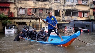People move in a boat past partially submerged vehicles in a residential area following heavy rains ahead of Cyclone Michaung in Chennai, India, December 4, 2023. (REUTERS)