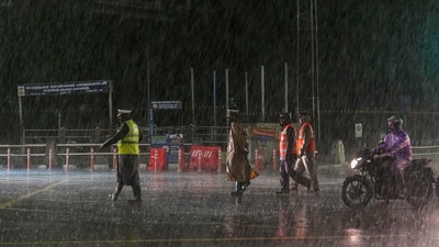 Police personnel on a road during heavy rain owing to Cyclone Michaung in Chennai on Sunday. (PTI) Police personnel on a road during heavy rain owing to Cyclone Michaung in Chennai on Sunday. (PTI)