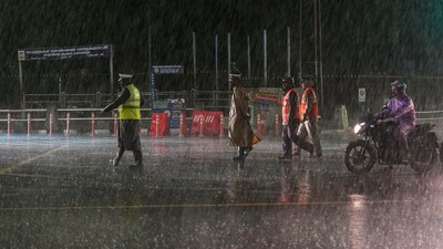 Police personnel on a road during heavy rain owing to Cyclone Michaung in Chennai on Sunday. (PTI) Police personnel on a road during heavy rain owing to Cyclone Michaung in Chennai on Sunday. (PTI)
