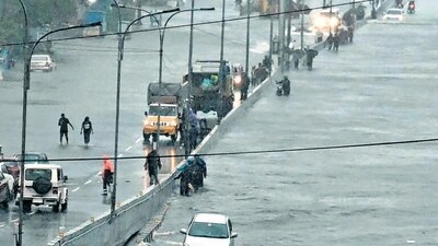 Commuters make their way through a flooded road after heavy rains in Chennai on Monday. (AFP) Commuters make their way through a flooded road after heavy rains in Chennai on Monday. (AFP)