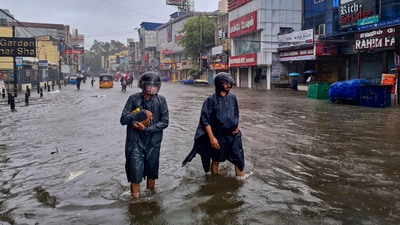People wade through a waterlogged road during heavy rain owing to Cyclone Michaung, in Chennai (PTI) People wade through a waterlogged road during heavy rain owing to Cyclone Michaung, in Chennai (PTI)