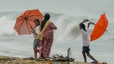 Locals visit the Marina Beach as high tidal waves lash the shore owing to Cyclone Michaung in Chennai, (PTI) Locals visit the Marina Beach as high tidal waves lash the shore owing to Cyclone Michaung in Chennai, (PTI)