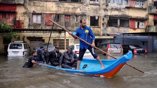 People move in a boat past partially submerged vehicles in a residential area following heavy rains ahead of Cyclone Michaung in Chennai, India, December 4, 2023.(REUTERS)