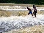 Youngsters at an overflowing lake after heavy rain owing to Cyclone Michaung, in Tirupati, Andhra Pradesh. Youngsters at an overflowing lake after heavy rain owing to Cyclone Michaung, in Tirupati, Andhra Pradesh.