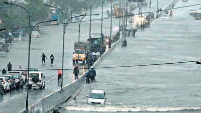 Commuters make their way through a flooded road after heavy rains in Chennai on Monday. (AFP) Commuters make their way through a flooded road after heavy rains in Chennai on Monday. (AFP)