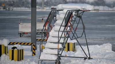 A towable passenger staircase is covered with snow as Munich Airport has cancelled all incoming and outgoing flights until 12 p.m. (1100GMT) due to a forecast for sleet in Munich, Germany, December 5, 2023. Picture taken through a fence.     REUTERS/Angelika Warmuth (REUTERS)