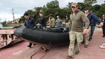 US military personnel carry a dinghy as they head out to search for the crash of a US CV-22B Osprey aircraft (AFP) US military personnel carry a dinghy as they head out to search for the crash of a US CV-22B Osprey aircraft (AFP)