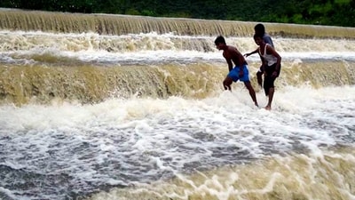 Youngsters at an overflowing lake after heavy rain owing to Cyclone Michaung, in Tirupati, Andhra Pradesh. (PTI) Youngsters at an overflowing lake after heavy rain owing to Cyclone Michaung, in Tirupati, Andhra Pradesh. (PTI)