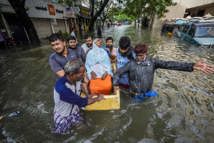 People help an elderly woman shift to a safer place from a flooded area after heavy rainfall owing to Cyclone Michaung in Chennai on Tuesday, (PTI) People help an elderly woman shift to a safer place from a flooded area after heavy rainfall owing to Cyclone Michaung in Chennai on Tuesday, (PTI)