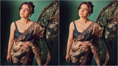 Her saree comes in an enchanting shade of teal green and features a luxurious organza fabric adorned with an alluring floral print. She draped it elegantly around her with the pallu falling beautifully from her shoulders. She paired it with a matching sleeveless blouse. (Instagram/@kajol) Her saree comes in an enchanting shade of teal green and features a luxurious organza fabric adorned with an alluring floral print. She draped it elegantly around her with the pallu falling beautifully from her shoulders. She paired it with a matching sleeveless blouse. (Instagram/@kajol)