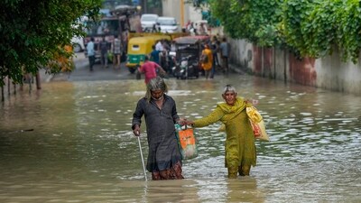 Locals wade through a flooded road at Jamuna Bazar area as the swollen Yamuna river floods nearby areas, in New Delhi, Friday, July 14. (PTI) Locals wade through a flooded road at Jamuna Bazar area as the swollen Yamuna river floods nearby areas, in New Delhi, Friday, July 14. (PTI)