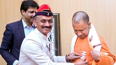 An armed forces personnel pins a flag on Chief Minister Yogi Adityanath on the occasion of Armed Forces Flag Day in Lucknow. (PTI) An armed forces personnel pins a flag on Chief Minister Yogi Adityanath on the occasion of Armed Forces Flag Day in Lucknow. (PTI)