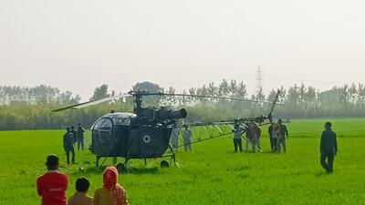 Villagers looking at the Indian Air Force helicopter after it landed in a field at Jathedi in Bilaspur sub division of Yamunanagar district on Thursday. (HT Photo)