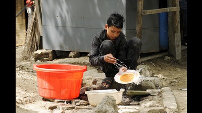 A child cleaning utensils at a roadside hotel. (Burhaan Kinu / Hindustan Times) A child cleaning utensils at a roadside hotel. (Burhaan Kinu / Hindustan Times)