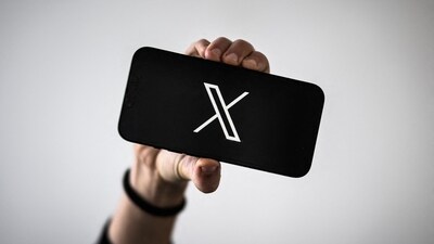 A woman holds a smartphone displaying the logo of US social network X (former Twitter). (AFP)