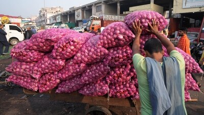 A worker loads a sack of onions on a cart at Azadpur Mandi (PTI) A worker loads a sack of onions on a cart at Azadpur Mandi (PTI)