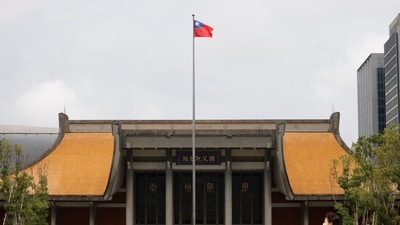People walk near a fluttering Taiwanese flag outside the Sun Yat-Sen Memorial Hall in Taipei, Taiwan. (Reuters)