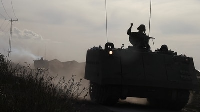 Israel-Hamas War: An Israeli soldier gestures while riding in an armoured personnel carrier (APC), amid the ongoing conflict between Israel and Hamas. (Reuters)